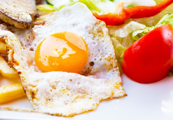Fried egg with potato fries, grilled steak.