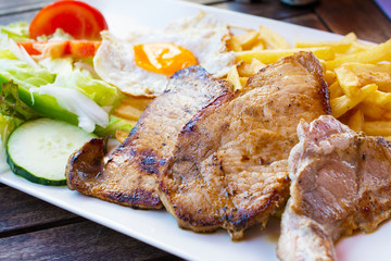 Grilled steaks, French fries, fried egg