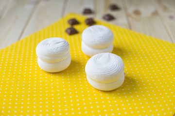 three white marshmallow on a yellow napkin