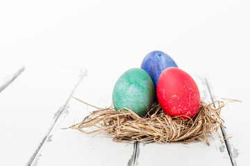 tre färgade ägg i fågelbo med utrymme för egen text
