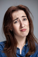 Naklejka premium Woman is looking imploring over gray background