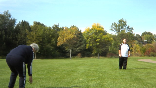 Senior couple playing Frisbee at park