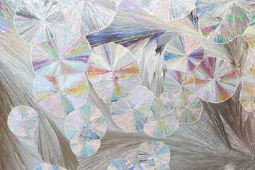 Artistic image of crystals of citric acid. These are synthetic crystals and displayed on a microscope glass slide. Photographed as seen through microscope.