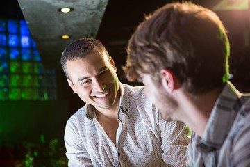 Happy men talking near a bar counter
