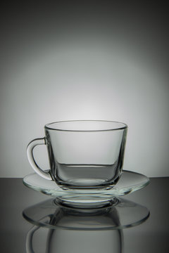 Glass empty mug of tea and saucer on a black and white backgroun