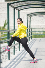 Young asian woman exercising outdoor in yellow neon jacket, stre