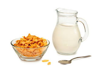 Corn flakes in a glass bowl and milk in glass jug isolated on white background