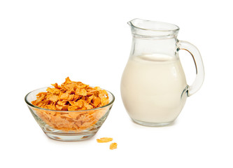 Corn flakes in a glass bowl and milk in glass jug isolated on white background