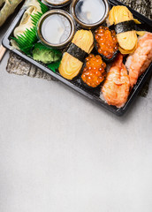 Sushi set with nigiri,  tamago egg , ama ebi raw prawn  and uni ikura on gray stone background, top view, place for text