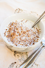 Table set for Breakfast. Buckwheat Porridge with Milk in White Bowl