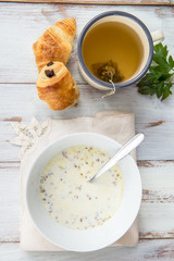 Table set for Breakfast. Buckwheat Porridge with Milk in White Bowl, Ginger Tea and Pastries