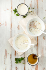 Table set for Breakfast. Buckwheat Porridge with Milk in White Bowls, Ginger Tea. Top View