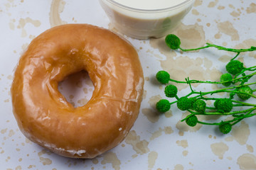 Donuts and milk for breakfast on wooden background.