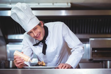 Chef putting sauce on a dish of spaghetti