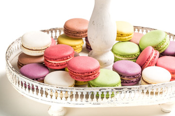 Delicious macaroons na plate on white background