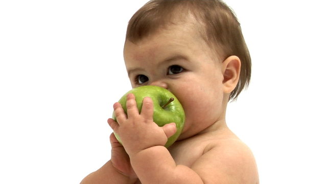Baby chewing on a green apple