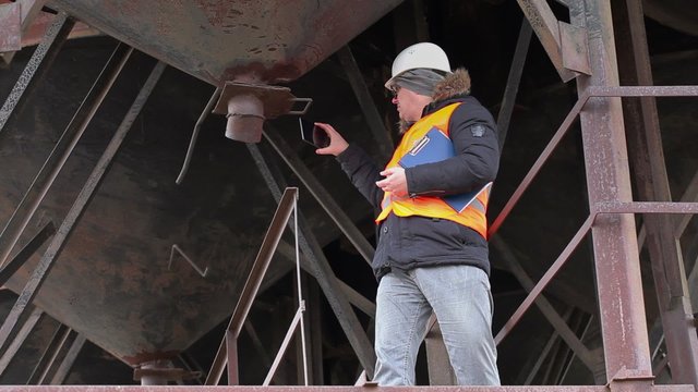 Engineer with tablet PC filming tanks