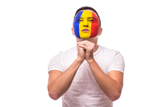 Pray for a goal Romanian football fan in game  of Romania national team on white background. European football fans concept.
