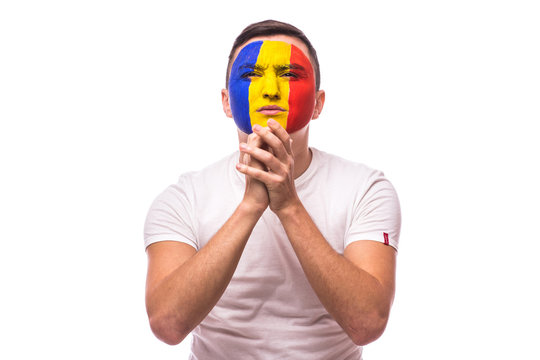 Pray and cry Romanian football fan in game  of Romania national team on white background. European football fans concept.