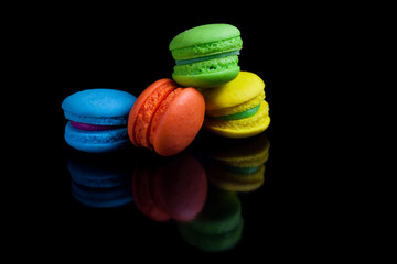 Colorful french macaroons on a black background.