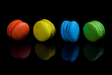 Colorful french macaroons on a black background.