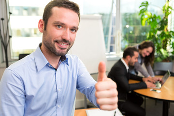 Young attractive businessman working at the office with associat