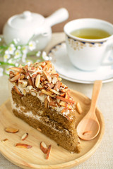 Coffee cake with almonds on top and cup of tea