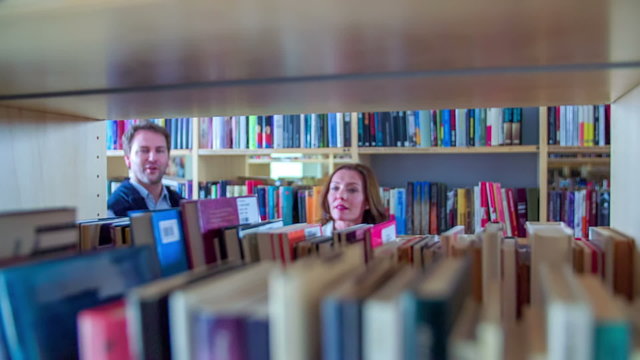 Couple reading books in library