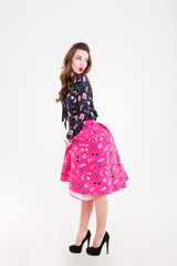 Playful cute young woman standing and looking back