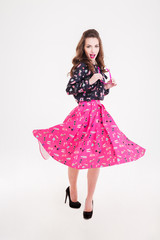 Naklejka premium Smiling beautiful young woman holding pink sunglasses and whirling around