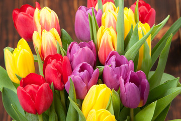 Fototapeta premium Assorted Tulips Bouquet. Burned Wooden Background. Copy Space