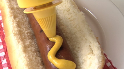 Putting mustard on a hot dog