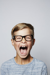 Boy in spectacles shouting at camera, portrait