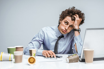 Distressed young manager man holds her head with hand. Modern office man at working place,...