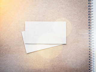 Blank business cards on kraft notebook cover, mockup