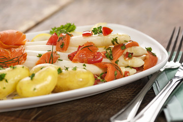 Gekochter Spargel mit Sauce Vinaigrette und  feinen Kartoffeln auf einem weißen Teller angerichtet