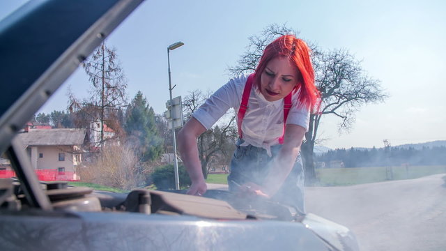 Woman fixing a broken car 