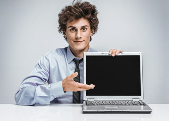 Young businessman showing at screen laptop / modern businessman at the workplace working with computer
