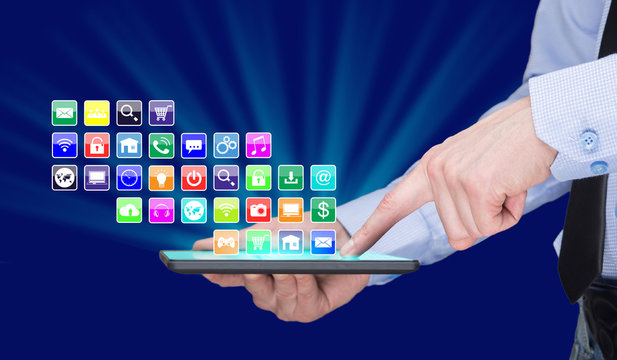 Businessman holding a tablet pc with mobile applications icons on virtual screen . Internet and business concept.