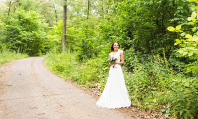 Bride holding bouquet of white calla lilies and blue flowers