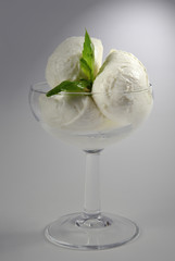 Mozzarelle nella coppa con foglia di basilico