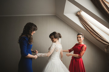 Naklejka premium Happy buddies helps bride getting ready for her wedding day in the morning 