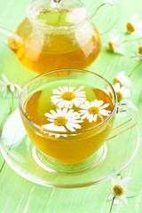 Chamomile tea on green table