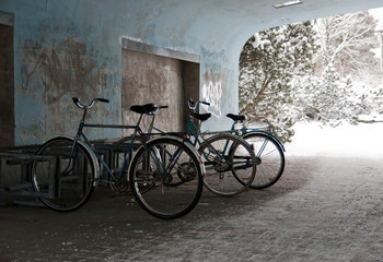 Fototapeta na wymiar Old bicycles parking at bike rack in railway station underpass.