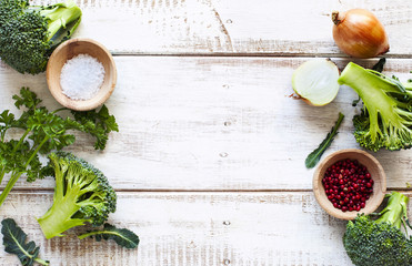 Fresh green broccoli, parsley, onion, salt and red pepper on woo