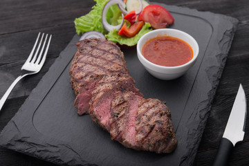 beef steak on with fresh salad on stone