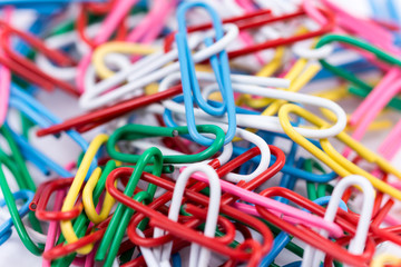 Pile of colorful metal paperclips in macro view