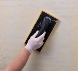 Applying plaster on the wall using a roller