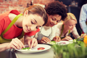 happy women cooking and decorating dishes