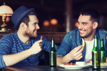 happy male friends drinking beer at bar or pub